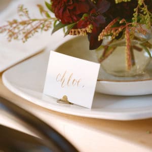 Place setting on plate at table with calligraphy writing.