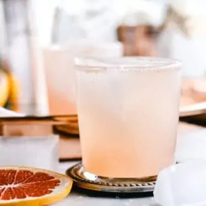 Grapefruit Collins Cocktail with Rosemary Simple Syrup on silver coaster.