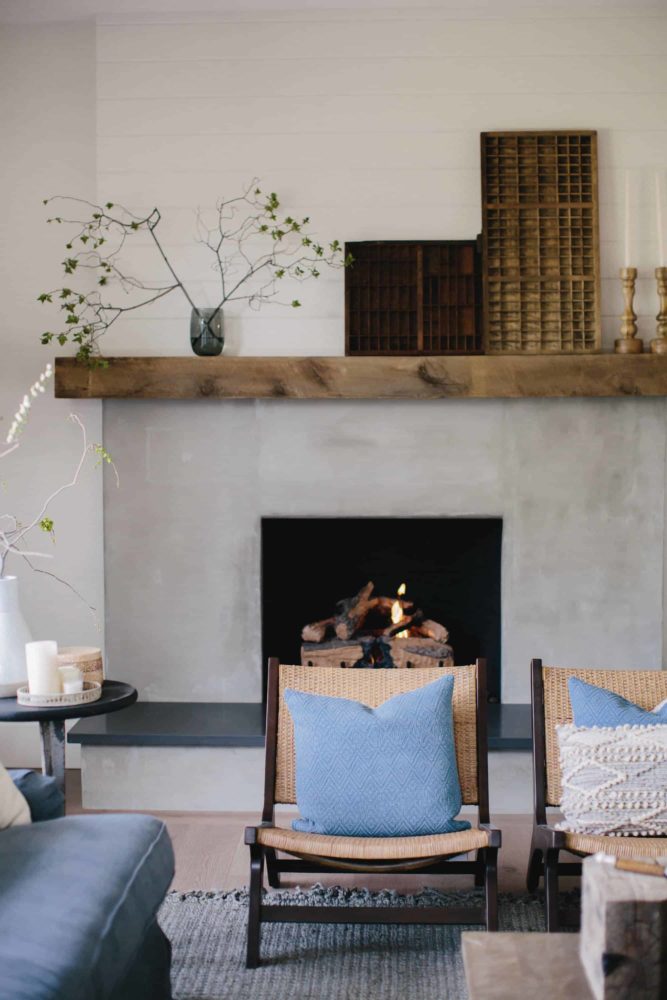 Cement fireplace with reclaimed wood beam, with living room furniture