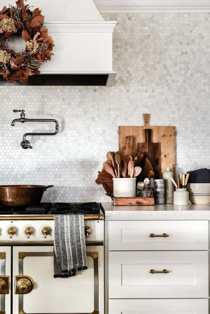 White modern farmhouse kitchen range and countertop with marble backsplash tile. 