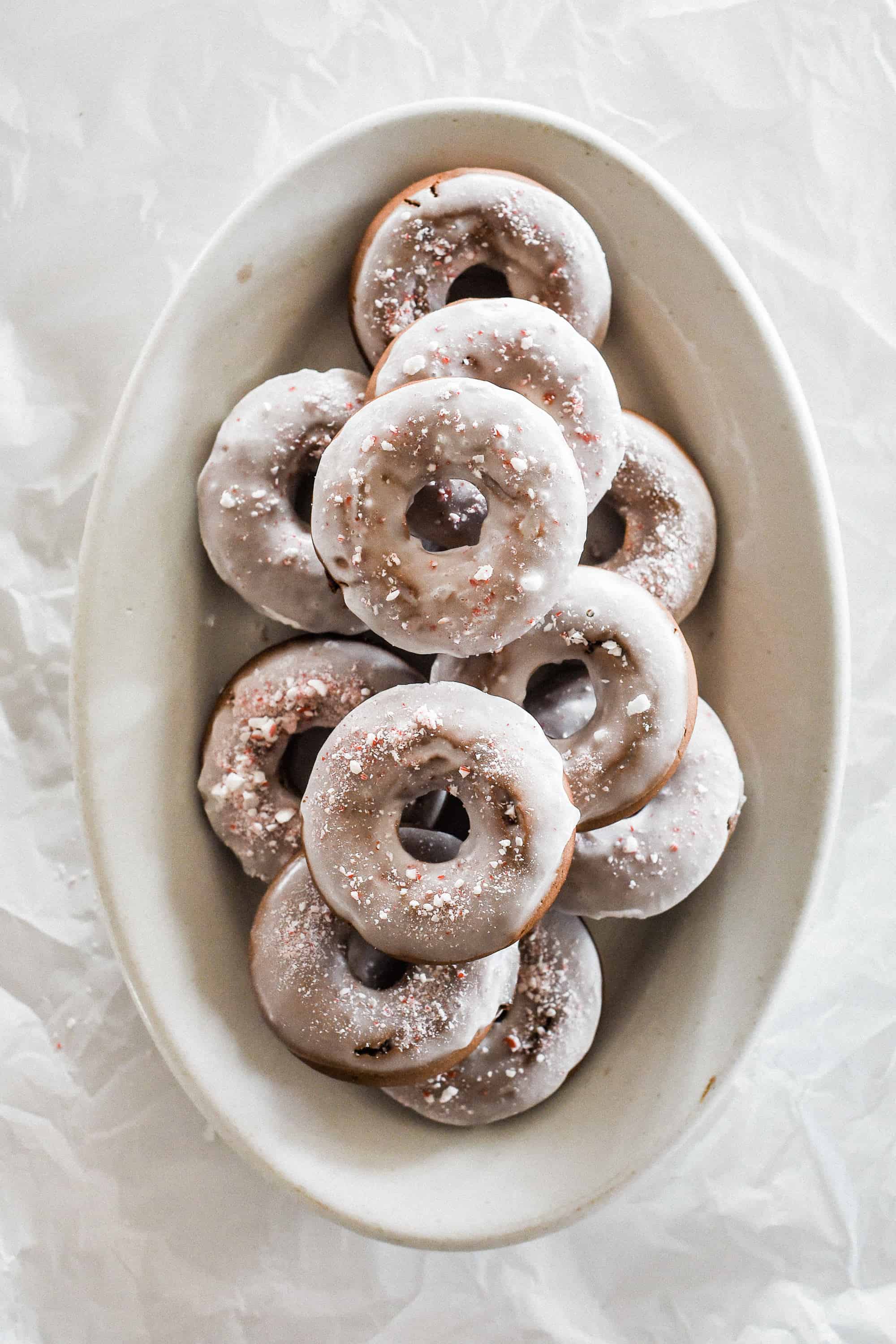 Baked peppermint bark Christmas donuts are the perfect treat to serve this holiday! These are fluffy, chocolatey, and have just the right amount of peppermint. 