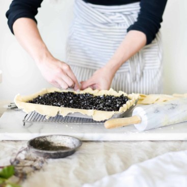 Elderberry pie being made on a marble slab.
