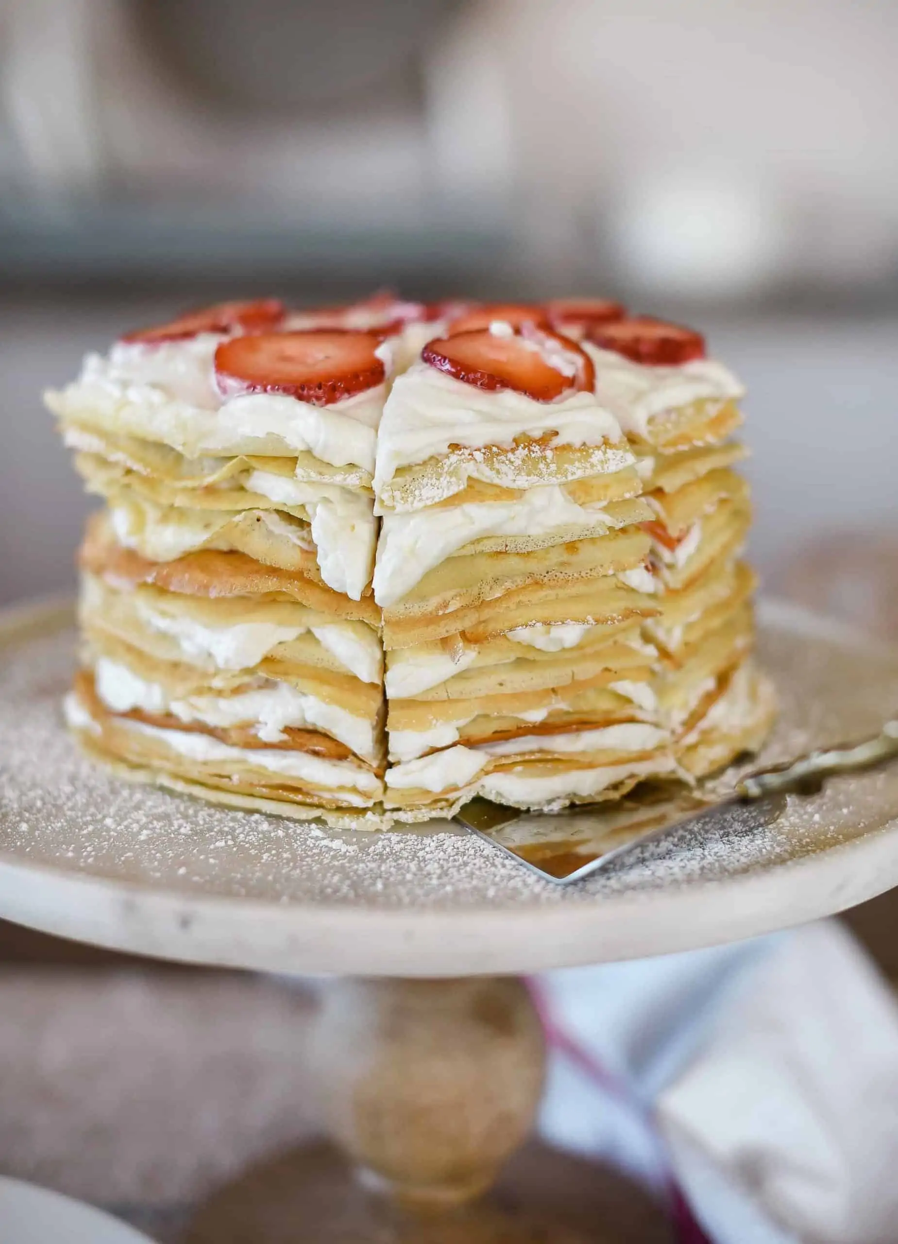 This crepe cake recipe is a show-stopper, and is perfect for special occasions! The cake is made of delicate crepes and filled with strawberries & whipped cream!