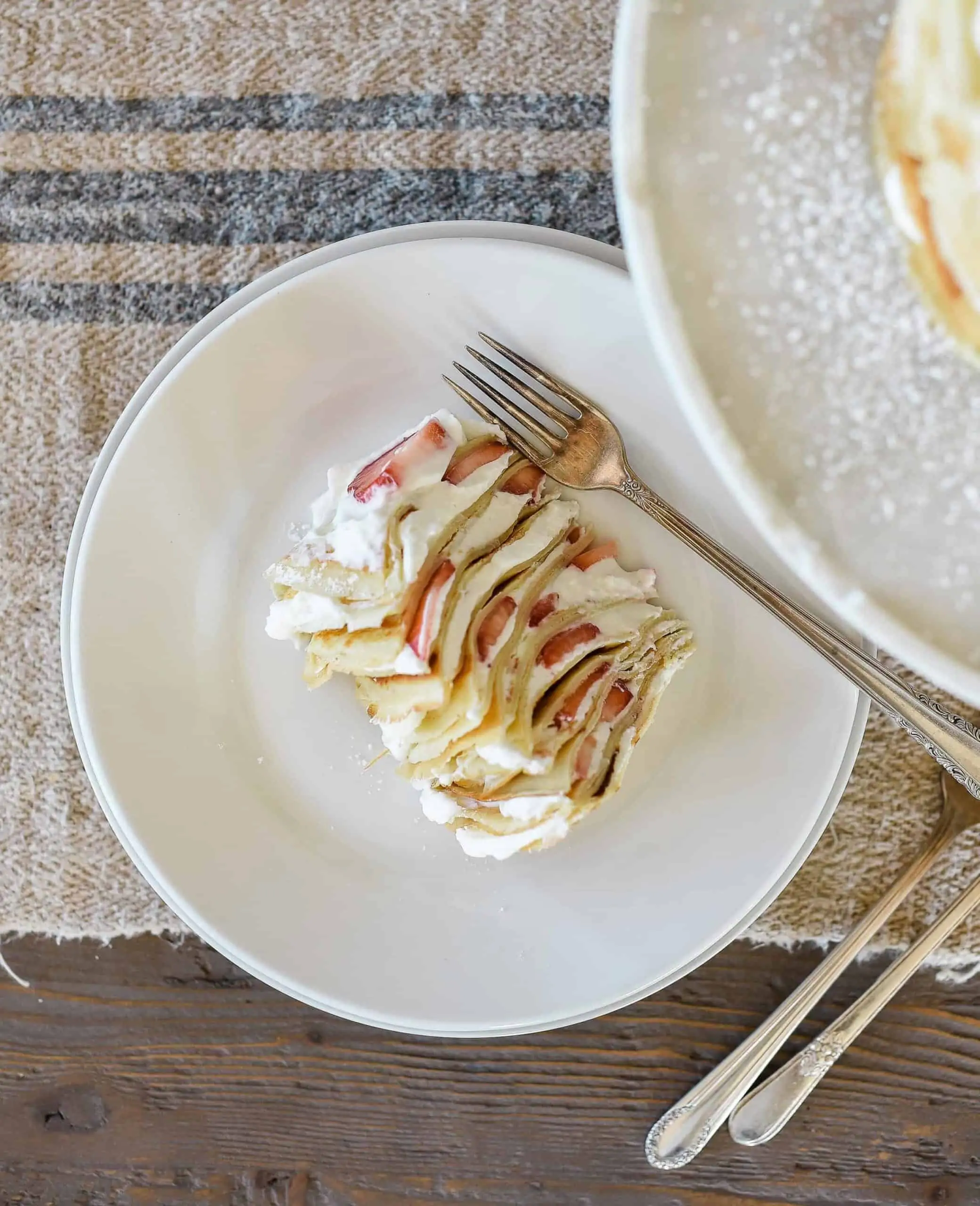 This crepe cake recipe is a show-stopper, and is perfect for special occasions! The cake is made of delicate crepes and filled with strawberries & whipped cream!