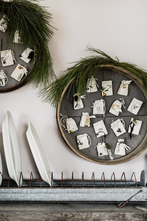 This DIY Christmas advent calendar is made using antique French grain sifters and muslin bags, plus click below to download each day’s printable for free!