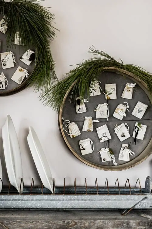 This DIY Christmas advent calendar is made using antique French grain sifters and muslin bags, plus click below to download each day’s printable for free!