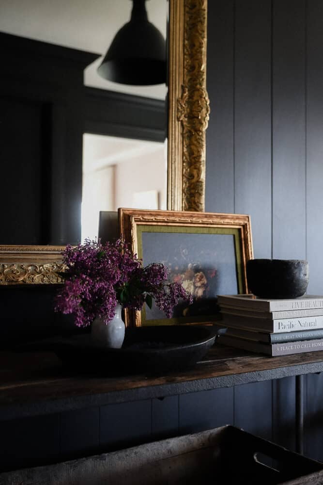 Dark entryway with mirror and oil painting on wood table