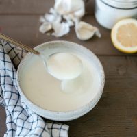 Bowl of garlic greek yogurt sauce on wood table