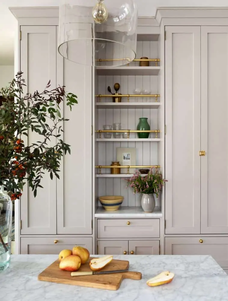 Creme colored cabinets with open shelving and brass rod detail