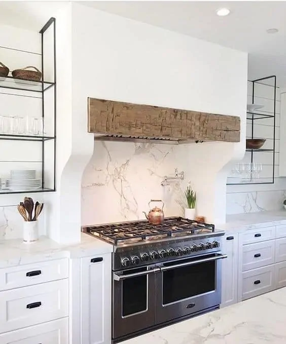 Metal shelves suspended from ceiling next to stainless steel range designed by Marie Flanagan