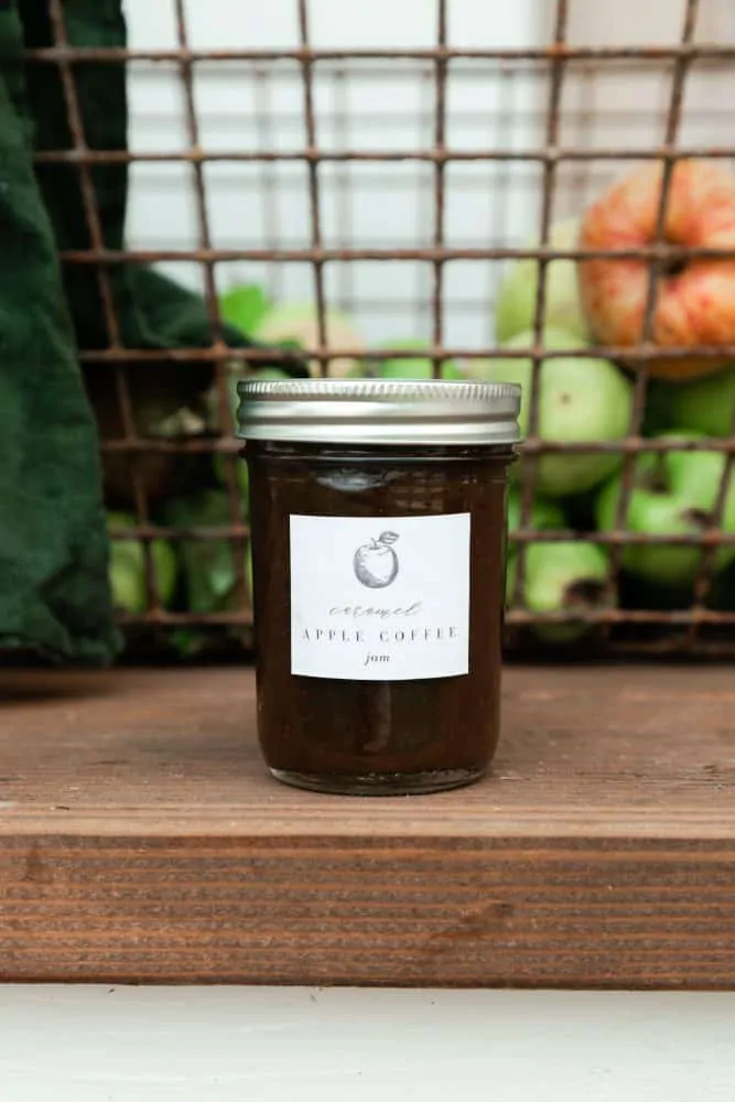 Apple preserves in mason jar in front of basket of apples