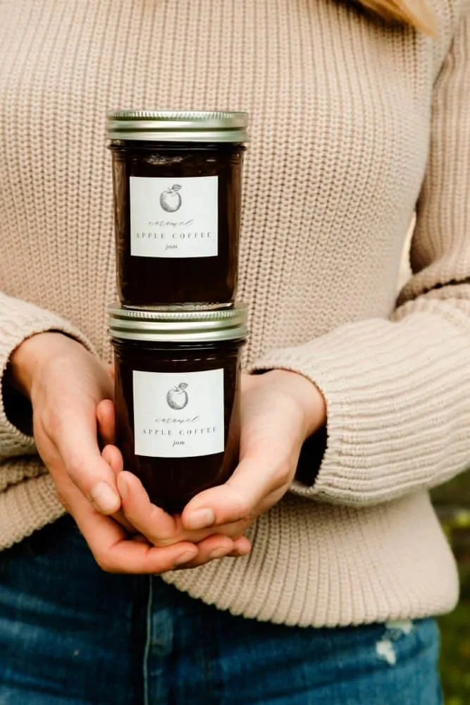 Girl holding fall apple preserves in sweater