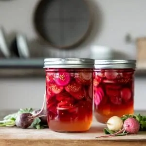Jar of pickled radishes on table