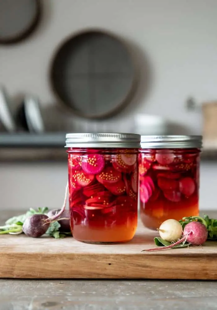 Jar of pickled radishes on table