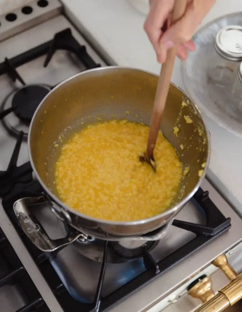 Double boiler on stove making orange curd.