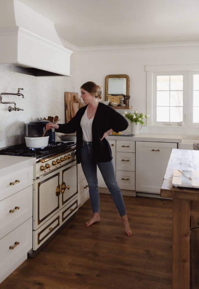 girl preserving orange marmalade at stove in white kitchen