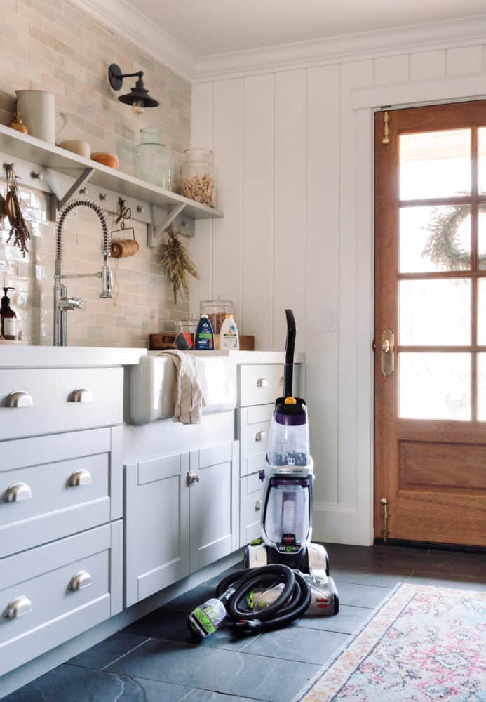 Laundry room with a Bissell vacuum cleaner standing up in the corner