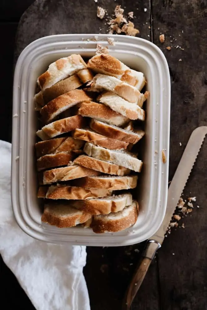Bread arranged in a herringbone pattern in a white baking dish
