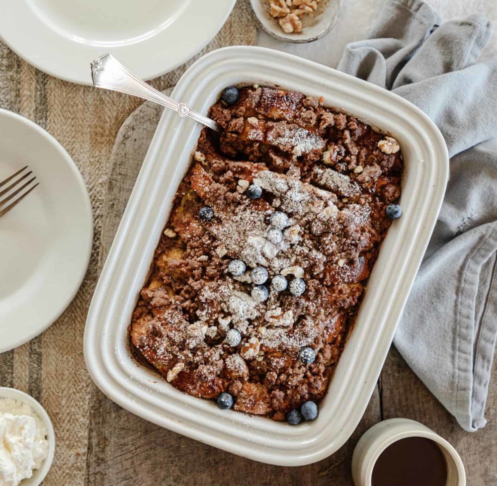 Birdseye view of baked french toast topped with powdered sugar and blueberries.