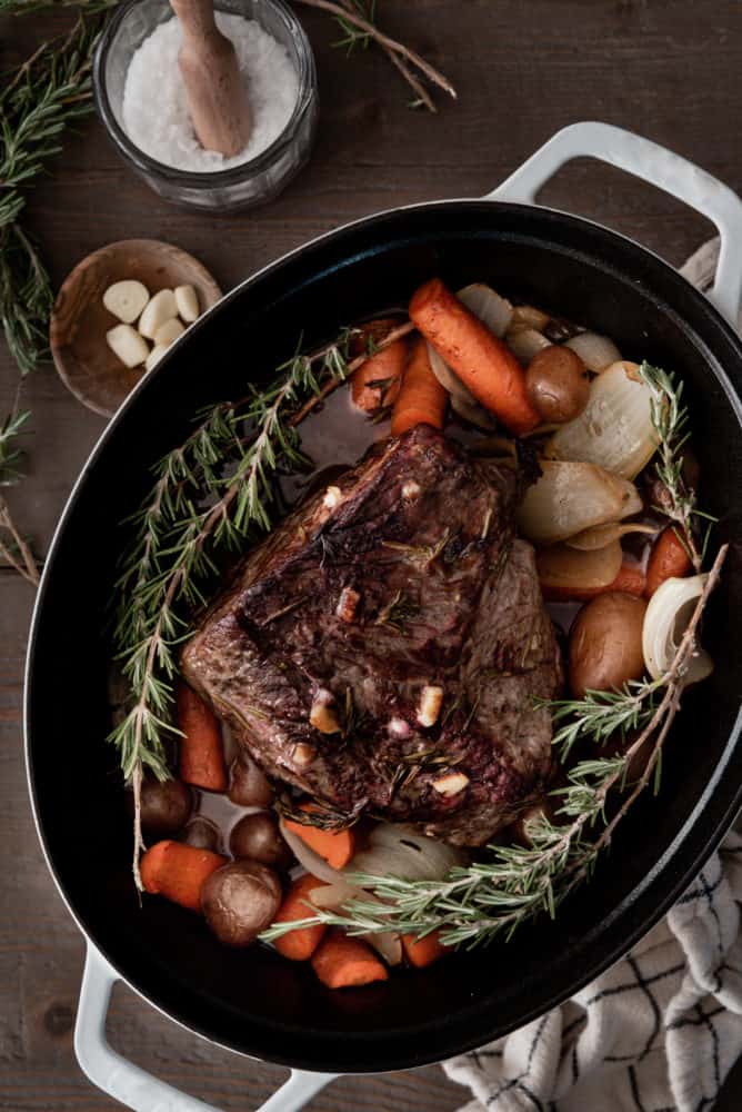 Rump Roast cooked in a Dutch oven with carrots, onions, potatoes and rosemary.