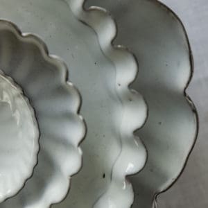 stacked scallop edged white french ceramic plates