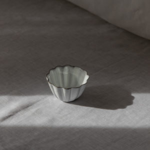 scalloped white small bowl on a linen draped backdrop