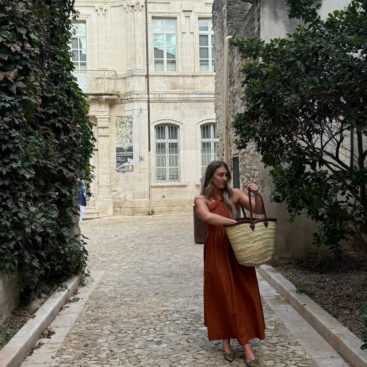 Chloe in the streets of Provence, France with a market bag.