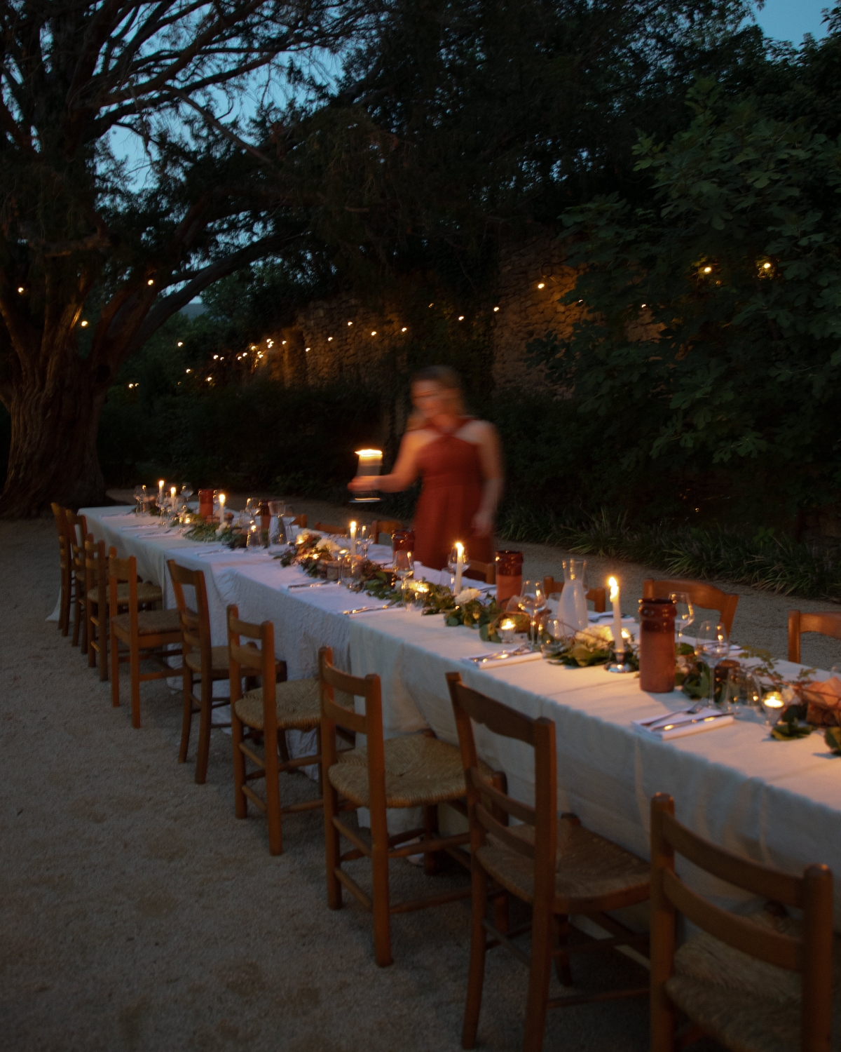 A curated Dinner in Provence with fresh greenery, candles, and a beautiful tablescape.