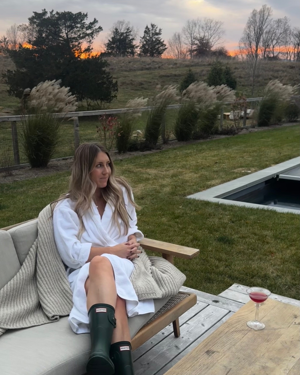 Chloe relaxing at the Jenni Kayne Farm in Tivoli, New York, just outside Hudson, enjoying a glass of wine while soaking in the peaceful beauty of the surrounding countryside.