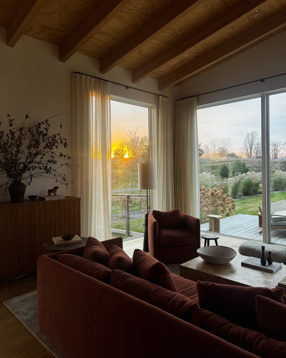 Elegant living room inside a Jenni Kayne farmhouse, featuring a blend of rustic charm and modern design, with light, airy spaces, natural textures, and carefully curated furniture that exudes comfort and style.